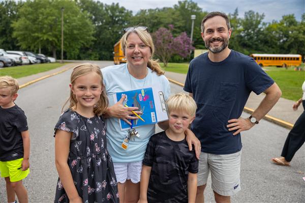 dad, teacher and two students smiling